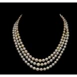 A three strand pearl princess length necklace