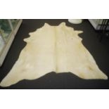 Large beige coloured cow hide rug