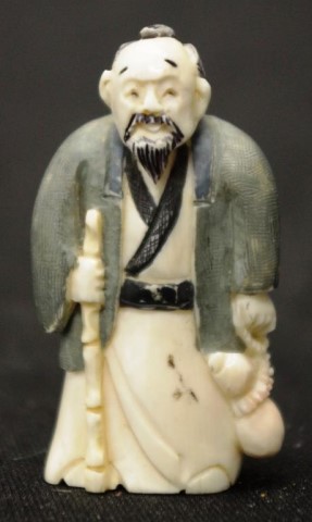 Early carved Ivory sage holding a stick netsuke