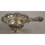 Silver tea strainer on stand