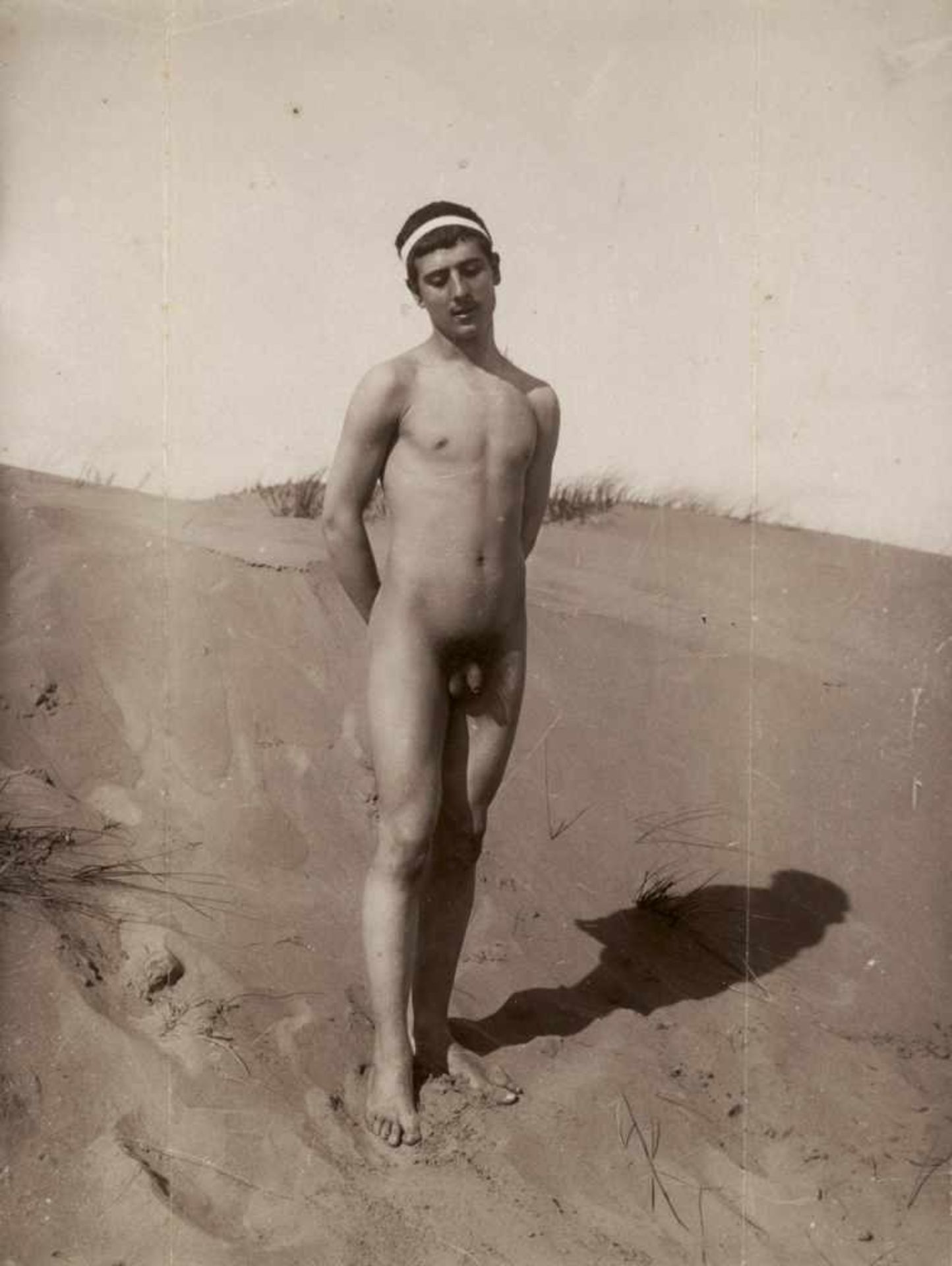 Gloeden, Wilhelm von: Nude youth on beachNude youth on beach. Circa 1900. Albumen print. 22,2 x 16,8