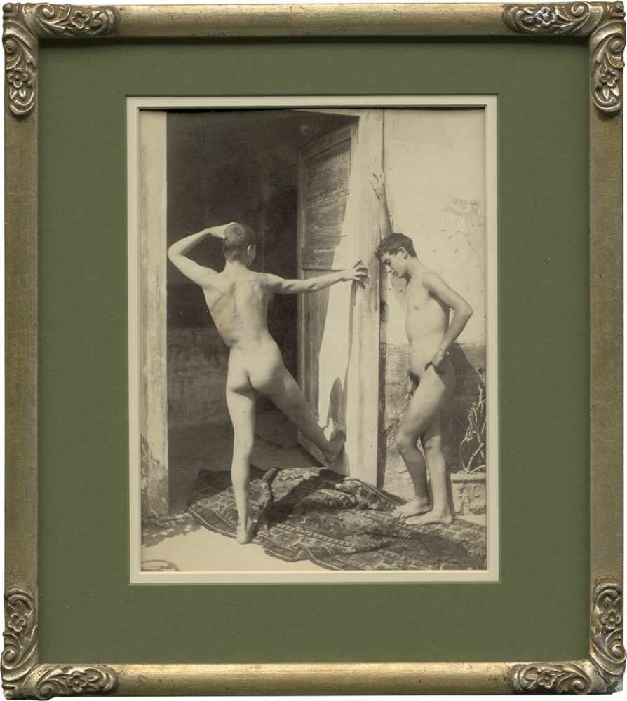 Gloeden, Wilhelm von: Two young nude boys in doorwayTwo young nude boys in doorway. Circa 1900.