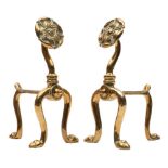 A pair of Art Nouveau brass fire dogs: on U-shaped front supports with Tudor rose terminals, 27cm.
