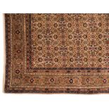A Sivas carpet:, the beige field with an all over geometric palmette, medallion and leaf design,