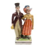 A Staffordshire pearlware group 'The Dandies': the fashionable lady holding a handbag,