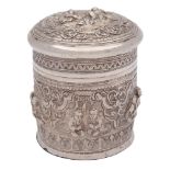 A Burmese silver jar and cover: the domed pull-off lid with embossed decoration of figures seated