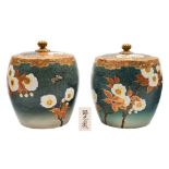 A pair of Satsuma earthenware jars and covers: of barrel shaped form decorated with flowering