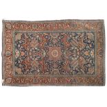 A Kashan rug:, the indigo field with a central geometric stellar medallion and all over palmette,