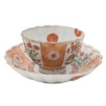 A Chinese famille verte fluted teabowl and saucer: painted with alternating panels of flowers and
