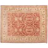 A contemporary Pakistan carpet:, the brick red field with all over geometric foliate design,