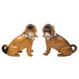 A pair of late 19th century Continental porcelain models of pug dogs: seated and wearing ribbon