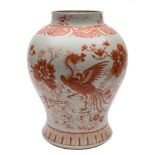 A Chinese porcelain baluster jar: decorated in iron red with a phoenix and tree peonies in a fenced