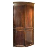 An early 19th Century mahogany and inlaid bow-fronted standing corner cupboard:,
