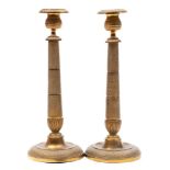A pair of 19th century French brass candlesticks: with urn-shaped nozzles on spiral decorated