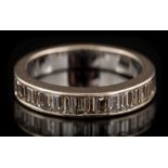 A baguette-cut diamond mounted half-eternity ring: the band channel-set with single row of