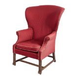 A George III carved mahogany wing frame armchair:, with a curved upholstered stuff over back,
