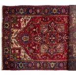 A Heriz rug:, the wine field with a central geometric lozenge flowerhead pole medallion,