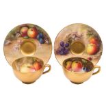 A pair of Royal Worcester fruit painted cabinet cups and saucers: painted respectively with apples,