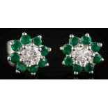 A pair of emerald and diamond mounted circular earrings: each with a central round,