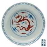A Chinese underglaze blue and iron-red dragon dish: the interior medallion decorated with a sinuous
