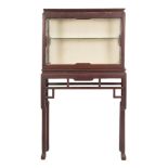 A Chinese hardwood rectangular display cabinet on a stand:, having glazed panel front,