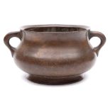 A Chinese bronze censer: the compressed circular body with angled rim, loop handles and flared foot,