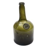 An 18th century sealed glass wine bottle: of squat cylinder form with shallow kick up,