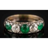 An emerald and diamond five-stone ring: with graduated oval emeralds between old brilliant-cut