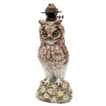 A large Whittmann & Roth 'owl' oil lamp: with glass eyes and on mound base applied with roses and