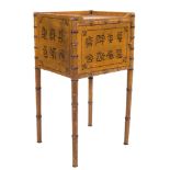 A 19th Century ochre painted and simulated bamboo pot cupboard:, with a tray top,