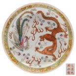 A Chinese famille rose phoenix and dragon dish: painted with a phoenix and dragon confronting a