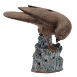 A Chinese stoneware model of a hawk: with brown biscuit plumage and dark markings,