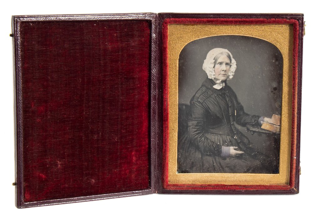 A cased daguerrotype of a seated woman:,