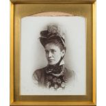A late 19th century portrait photograph on opaque glass:, of a woman looking to dexter,