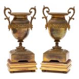 A pair of 19th century gilt metal twin-handled urns: of classical design with scroll handles to the