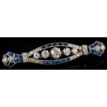 A synthetic sapphire and diamond elliptical bar brooch: set with graduated old,