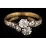An early 20th century gold and diamond crossover ring: with two principal round old,