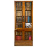 An oak library door with book spine fronts:, on a plinth base,