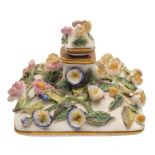 A Rockingham flower encrusted perfume bottle and stopper: of compressed square section applied with