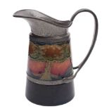 A Moorcroft pottery pewter mounted jug: of tapering cylindrical form with hammered pewter mounts,