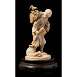 A Japanese carved ivory okimono of a woodcutter: the figure in traditional robes holding an axe in
