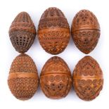 A collection of six carved egg-shaped coquilla nut pomanders: with concentric ringed,