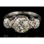 An illusion-set diamond three-stone ring: the principal round old-cut diamond approximately 8mm