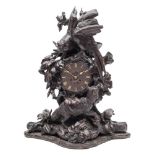 A Black Forest carved walnut mantel clock: the eight-day French movement striking the hours and