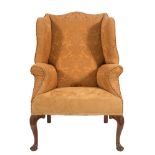 A carved walnut wing frame armchair in the early 18th Century taste:, fully upholstered,