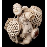 A Japanese carved and stained ivory okimono of a basket seller,