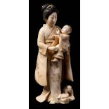 A Japanese carved ivory okimono of a bijin: carrying a young boy,