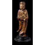 A Chinese carved soapstone figure of Guanyin: with chignon-tied upswept hair and wearing loose