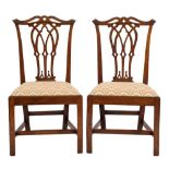 A pair of George III mahogany dining chairs in the Chippendale taste:,
