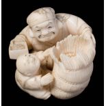 A Japanese carved ivory netsuke: depicting Daikoku with a bale of rice and a karako boy,